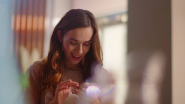 Woman receiving message on mobile phone at home. Girl looking on cellphone