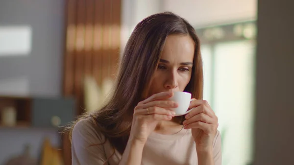 Nöjd kvinna dricker te i köket. Lady njuter av en kopp kaffe hemma — Stockfoto