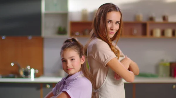 Mother and daughter in aprons crossing hands on kitchen in slow motion — Stok fotoğraf