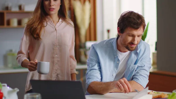 Forretningsmann og kvinne som bruker bærbar PC hjemme. Mann og kvinne som snakker på kjøkkenet – stockfoto
