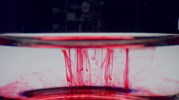 Laboratoriumglaswerk met bloedmonster. Rood chemisch reagens dat in water stroomt — Stockvideo