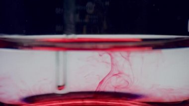 Su ve kırmızı reaksiyonlu test tüpü. Yakın çekim laboratuarı kanla kaplı.