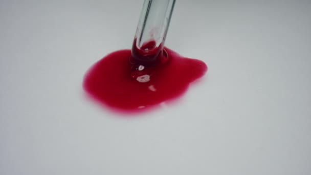 Медицинский исследователь, помешивающий кровь пипеткой. Капля крови на белом фоне — стоковое видео
