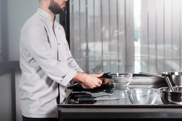 Mãos masculinas de chef com facas. Closeup pessoal de cozinha de testes profissional . — Fotografia de Stock