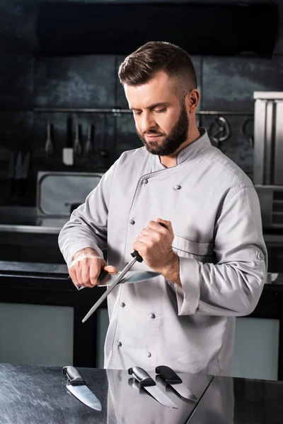 Szef kuchni mężczyzna z nożami w kuchni restauracji. Kuchenka w jednolitym ostrym nożu. — Zdjęcie stockowe