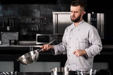 Restoran mutfağında tavalı bir aşçı. Wok 'un profesyonel şefi..