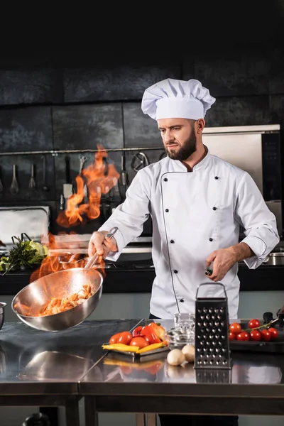 Szef kuchni przygotować jedzenie z pożaru w restauracji w kuchni. Szef kuchni z wokiem w kuchni. — Zdjęcie stockowe