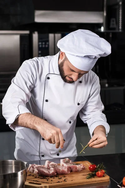 Homem chef cozinheiro bife no restaurante da cozinha. Chef em carne de pimentão uniforme . — Fotografia de Stock