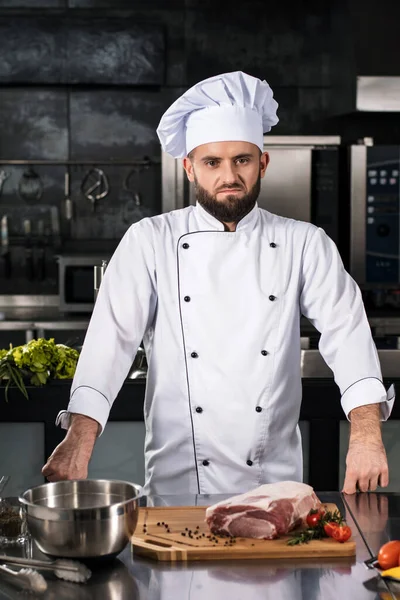 A séf kész nyers húst főzni. Szakács férfi tartózkodás a professzionális konyhában. — Stock Fotó