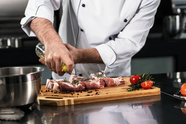 As mãos de chef preparam o bife na cozinha. Closeup mãos de carne de óleo em pranchado . — Fotografia de Stock