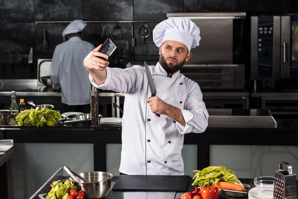 Mężczyzna kucharz robi zdjęcia w profesjonalnej kuchni. Cook podejmowania zdjęć mobilnych. — Zdjęcie stockowe