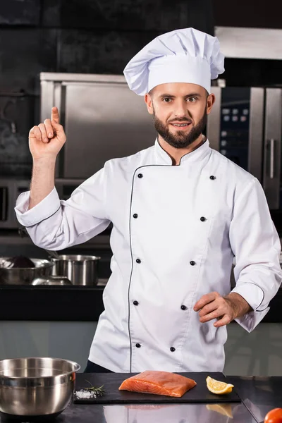 Szef kuchni z łososiem w kuchni restauracji. Portret kucharza krojącego filety rybne. — Zdjęcie stockowe