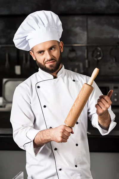 Chef man with roller at kitchen restaurant. Portrait of chef with rolling pin. — Stock Photo, Image