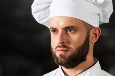 Mutfak restoranında aşçı adam. Koyu arkaplanda profesyonel portresi.