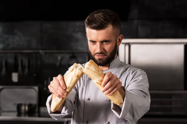 Szef kuchni w restauracji. Portret mężczyzny profesjonalne łamanie chleba. — Zdjęcie stockowe