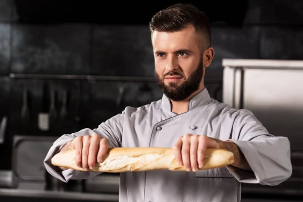 Szef kuchni w restauracji. Portret profesjonalisty z francuskim chlebem. — Zdjęcie stockowe