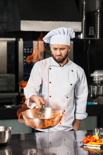 O chefe cozinhava comida na cozinha. Chef macho preparar comida asiática com fogo . — Fotografia de Stock