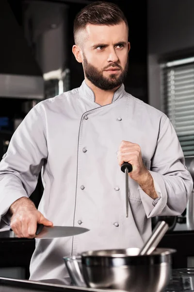 Szef kuchni mężczyzna z nożem w kuchni restauracji. Profesjonalny w mundurze ostry nóż. — Zdjęcie stockowe