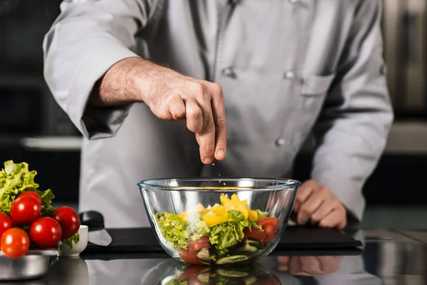 O chefe cozinha legumes no restaurante da cozinha. Closeup chef mão salgada comida . — Fotografia de Stock