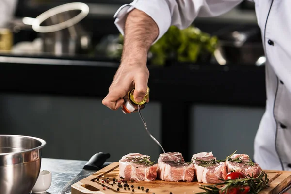 Chef mãos derramar carne no restaurante da cozinha. Closeup chef mãos spray de carne . — Fotografia de Stock