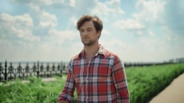 Adam parkta yolda yürüyor. Dışarıdaki kol saatini kontrol eden adam.