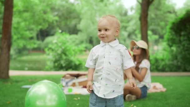 Un niño sonriente parado en el parque. Niños jugando juntos al aire libre — Vídeos de Stock