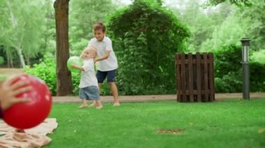 Park yerinde topla oynayan iki kardeş. Dışarıda battaniyenin üzerinde oturan tatlı kız kardeş.