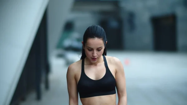 Mujer en forma de primer plano saltando en la cuerda saltar al aire libre. Mujer cansada terminando el ejercicio — Foto de Stock