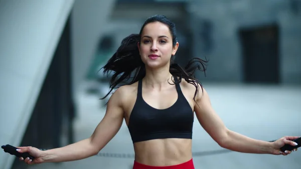 Ajuste mujer saltar con saltar la cuerda al aire libre. Atleta mujer practicando salto — Foto de Stock