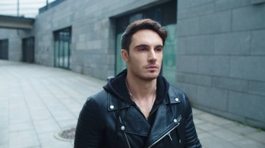 Ağır çekimde yürüyen hipster bir adamın portresi. Odaklanmış adam yürüyen şehir