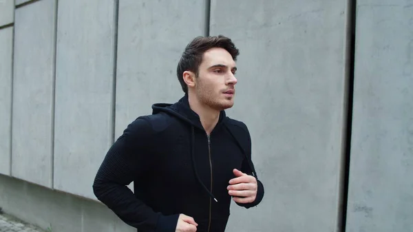 Close up sportsman running outdoor. Handsome guy running upstairs in slow motion