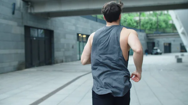 Fit man running outdoor in slow motion. Back view of athlete man training run — Stockfoto