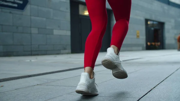 Acercamiento piernas femeninas trotando en la calle urbana. Atleta mujer piernas corriendo al aire libre —  Fotos de Stock
