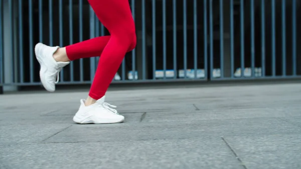 Cerrar las piernas femeninas corriendo al aire libre en cámara lenta. Ejecutar entrenamiento mujer fitness —  Fotos de Stock