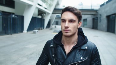 Yürüyen caddeye yakın genç adam. Şehre giden gülümseyen adamın portresi.