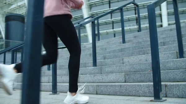 Primer plano piernas femeninas corriendo escaleras arriba al aire libre. Close up sport mujer trotando —  Fotos de Stock