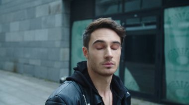 Şehirdeki caddede yürüyen yakışıklı adam. Genç adam şehir sokağına çıkıyor