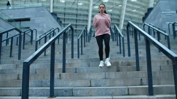스 포티 한 여자가 계단을 내려가고 있어요. 계단을 뛰어내려 달리는 달리기 선수 — 스톡 사진
