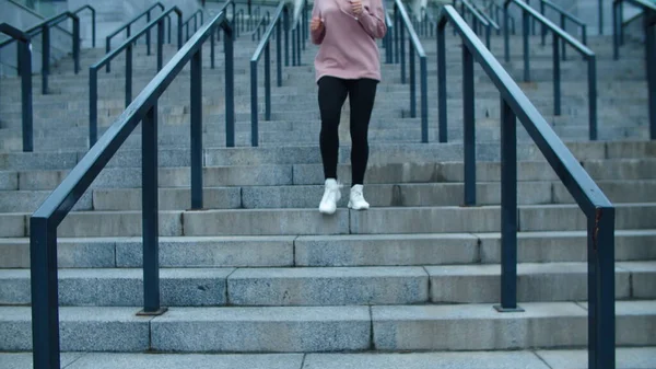 Fitte Frau, die in Zeitlupe eine Treppe hinunterläuft. Athletin entspannt nach Lauf — Stockfoto