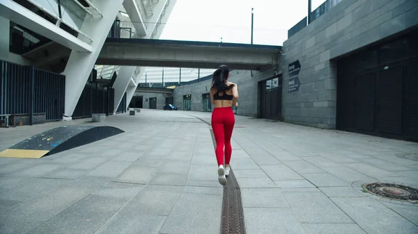 옥외에서 달리는 운동 선수인 여자. 뒷 쪽을 보면 러닝걸 훈련 운동 — 스톡 사진