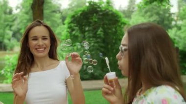 Aile dışarıda oynuyor. Çocuklar parkta dinlenirken gülen ebeveynler
