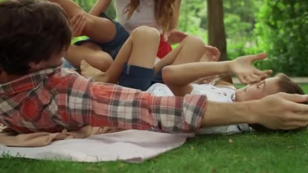 Rodina si spolu hraje v letním parku. Rodiče lechtají děti venku — Stock video