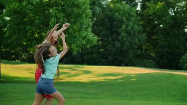 Familjen leker med bollen i sommarparken. Positiva föräldrar kastar boll i luften — Stockvideo