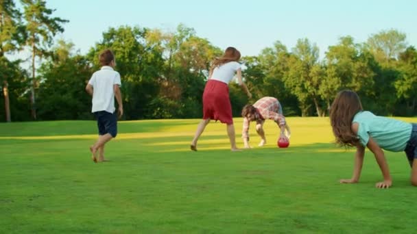 Homem segurando bola em mãos ao ar livre. Mãe com crianças tentando pegar bola — Vídeo de Stock