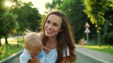 Parkta duran kadın ve çocuk. Anne ve oğlu sabun köpüğüyle oynuyor.