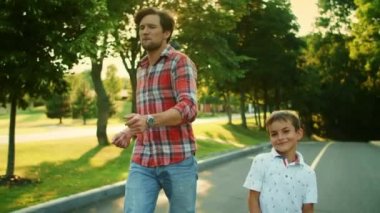 Sokakta yürüyen olumlu bir adam ve çocuk. Mutlu baba ve oğul dışarıda dans ediyor.