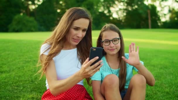 Mädchen winkt während eines Videogesprächs in die Kamera. Familie spricht auf dem Smartphone — Stockvideo