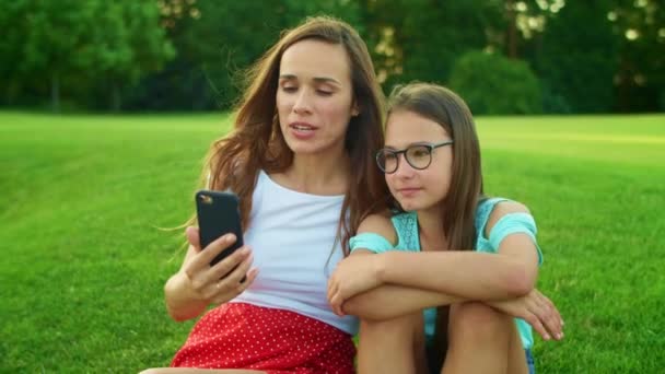 Matka a dcera mluví on-line prostřednictvím videohovoru na mobilu v letním poli — Stock video