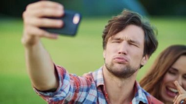 Neşeli aile dışarıdaki akıllı telefon kamerasında komik suratlar yapıyor.