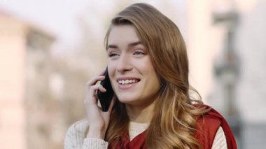Dışarıda cep telefonundan konuşan duygusal bir kadın. Heyecanlı kız cep telefonunu arıyor.